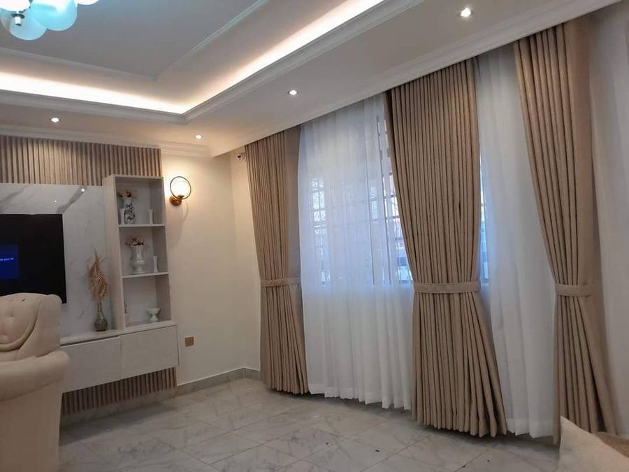 Beige curtains and sheer drapes fitted in a living room