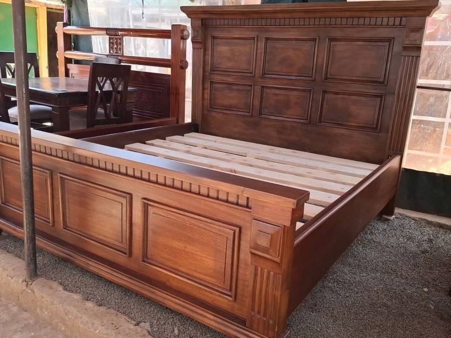 Carved wooden bed frame with panelled headboard