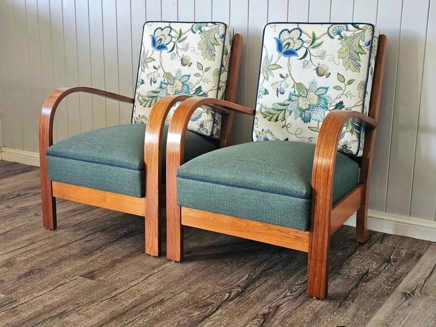 Matching wooden-armed chairs with floral cushions